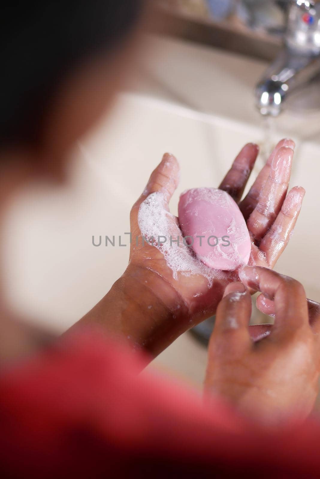 young man washing hands with soap warm water.