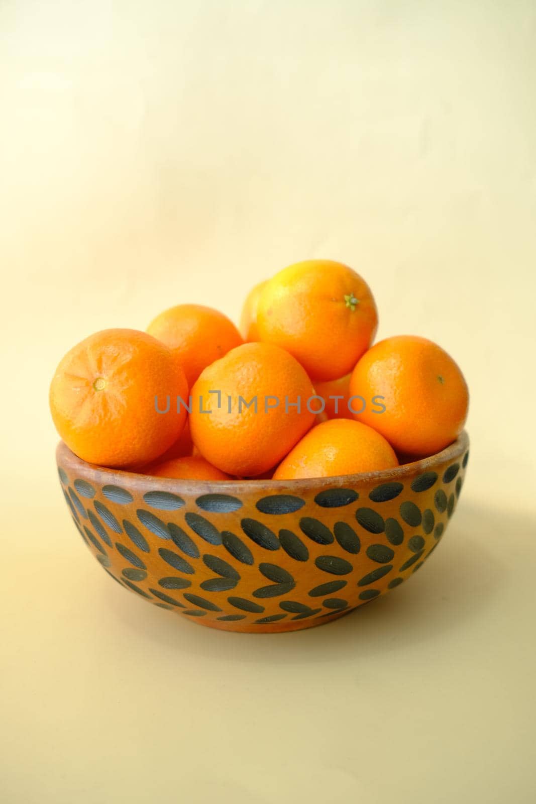 slice of orange fruits in a bowl on light yellow background by towfiq007