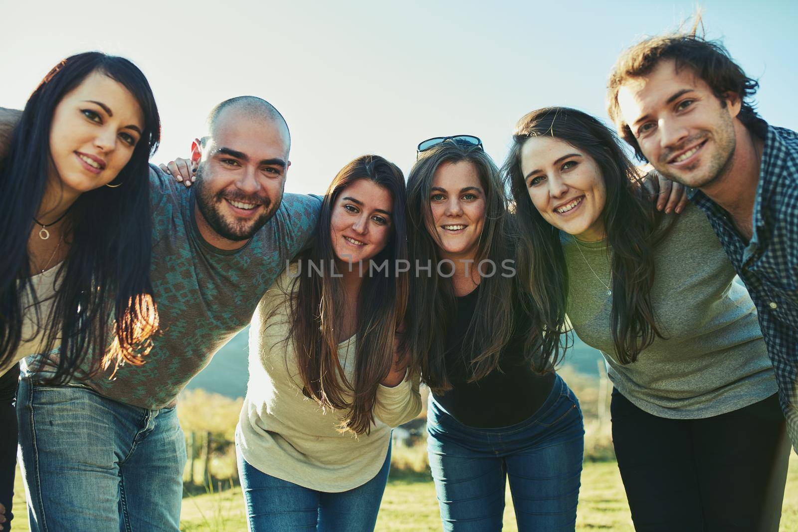 Just chilling together. Portrait of a group of friends enjoying some time outdoors together. by YuriArcurs