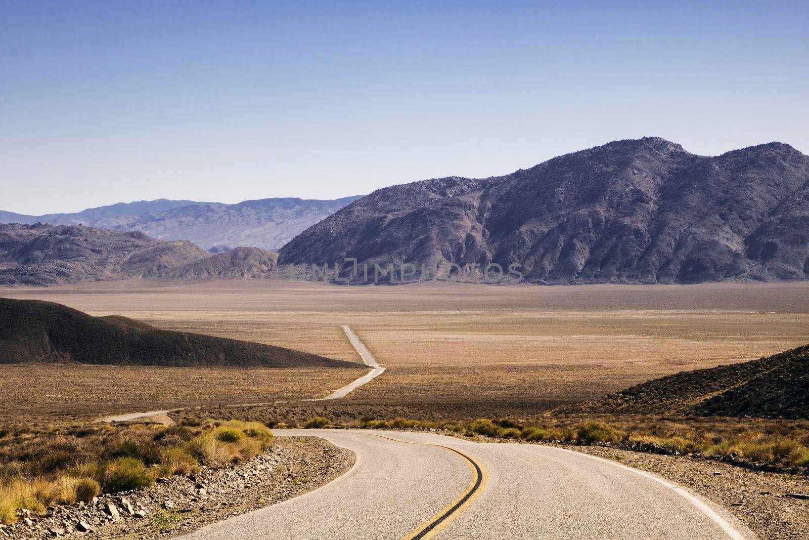 Curved road crossing a desert area in California