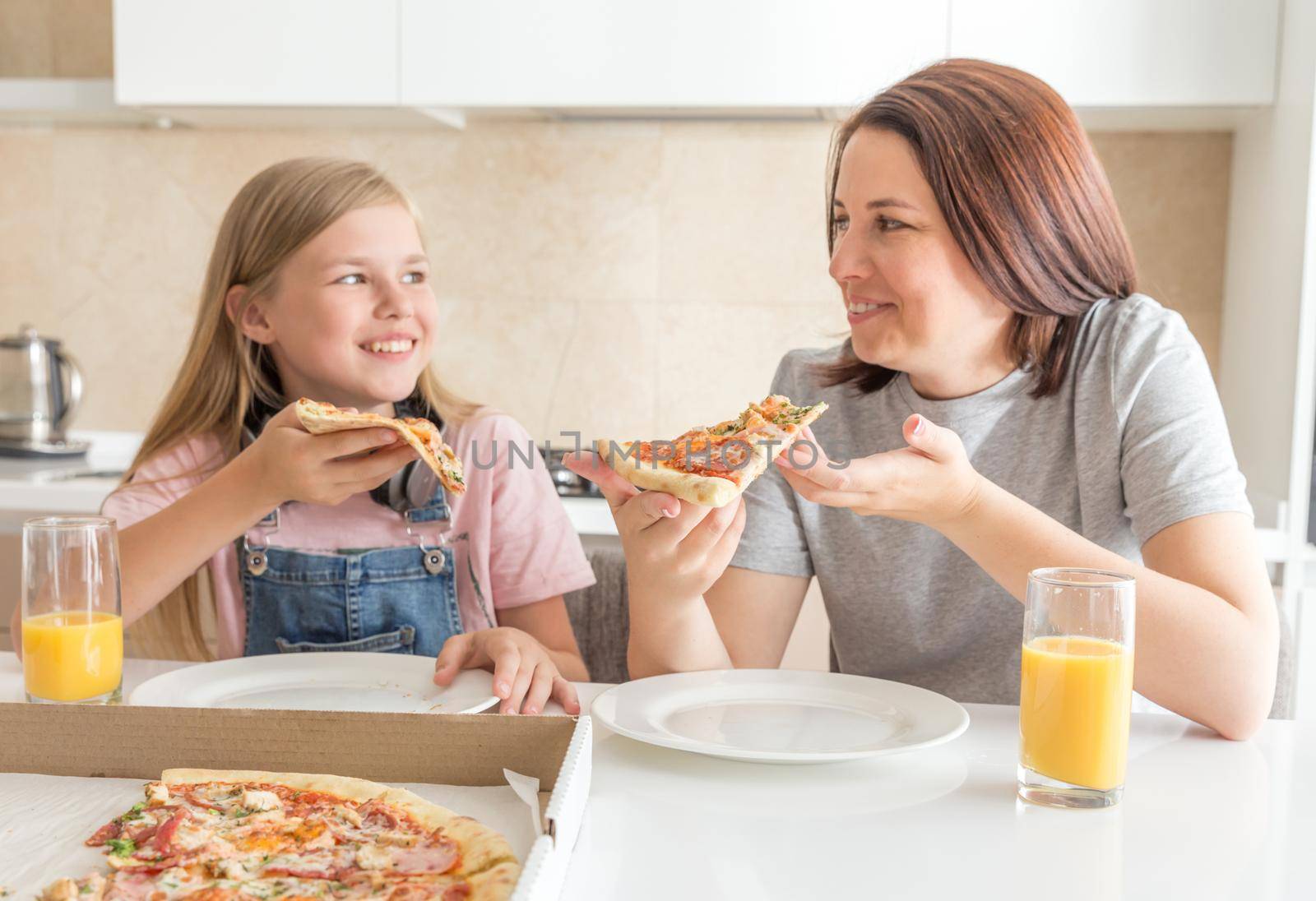 Family concept, Mother and daughter eating a tasty pizza by Mariakray
