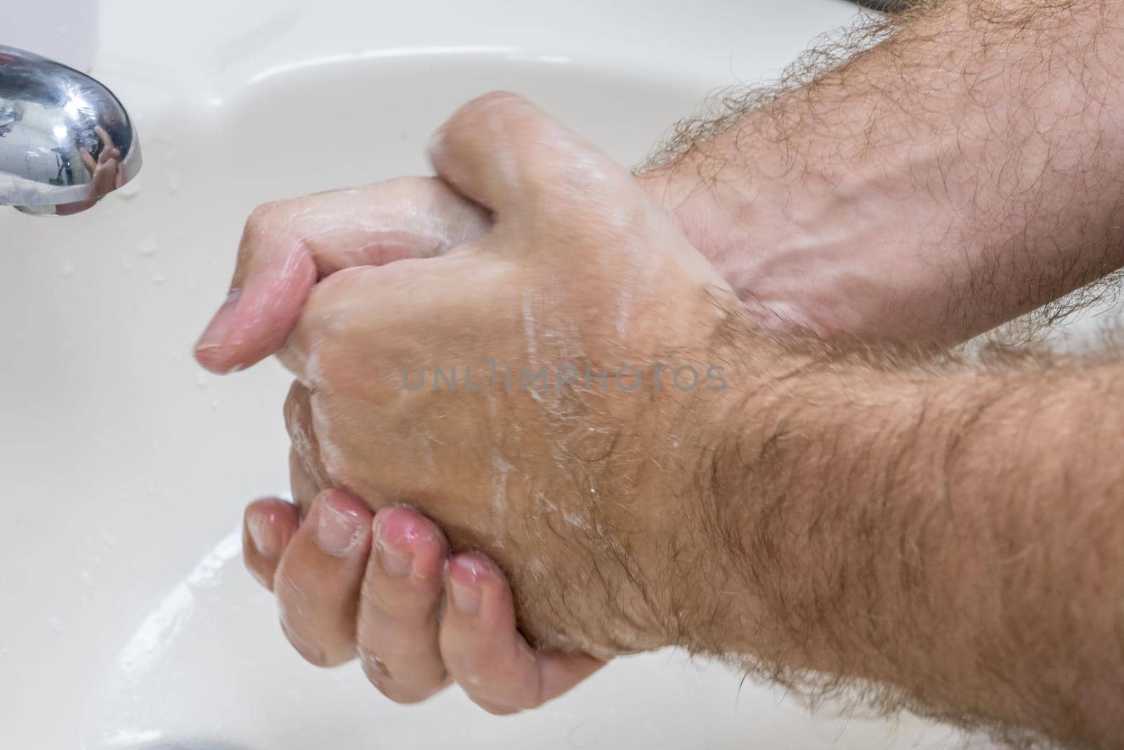 Man washing hands in basin close-up by imagesbykenny