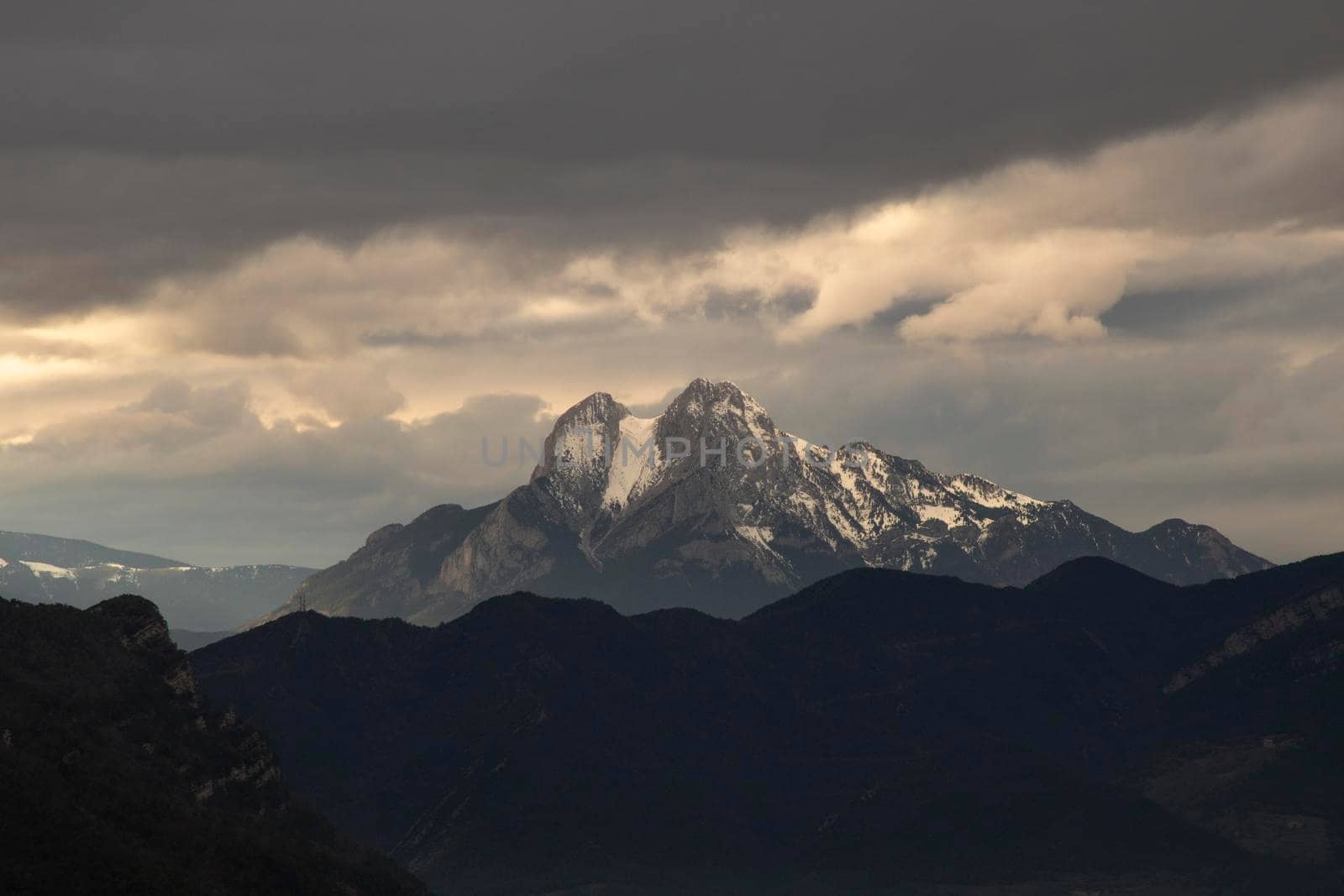 Landscape showing Pedraforca mountain covered by snow and a cloudy sky over it