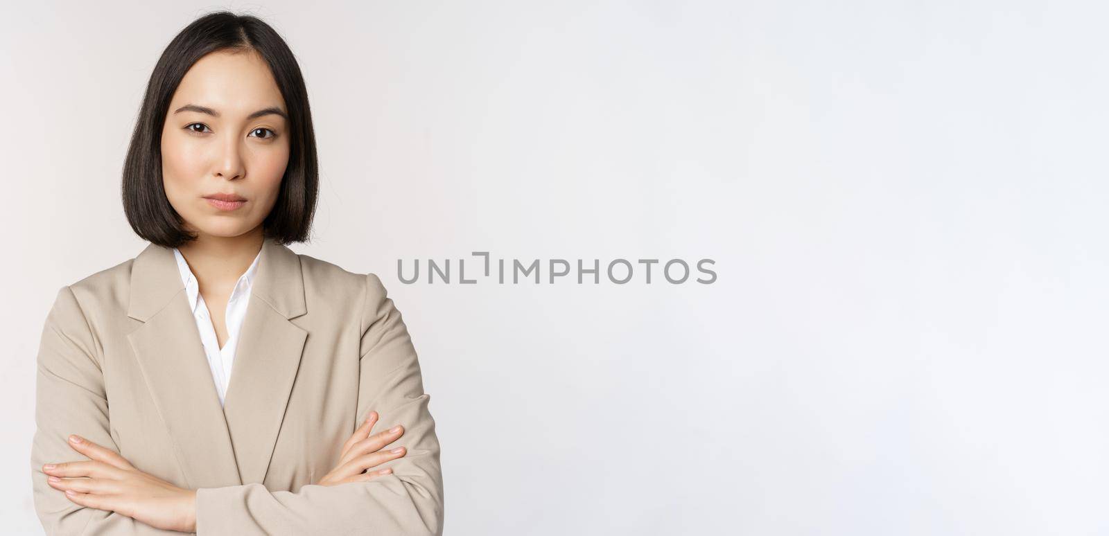 Confident female entrepreneur, asian business woman standing in power pose, professional business person, cross arms on chest, standing over white background by Benzoix