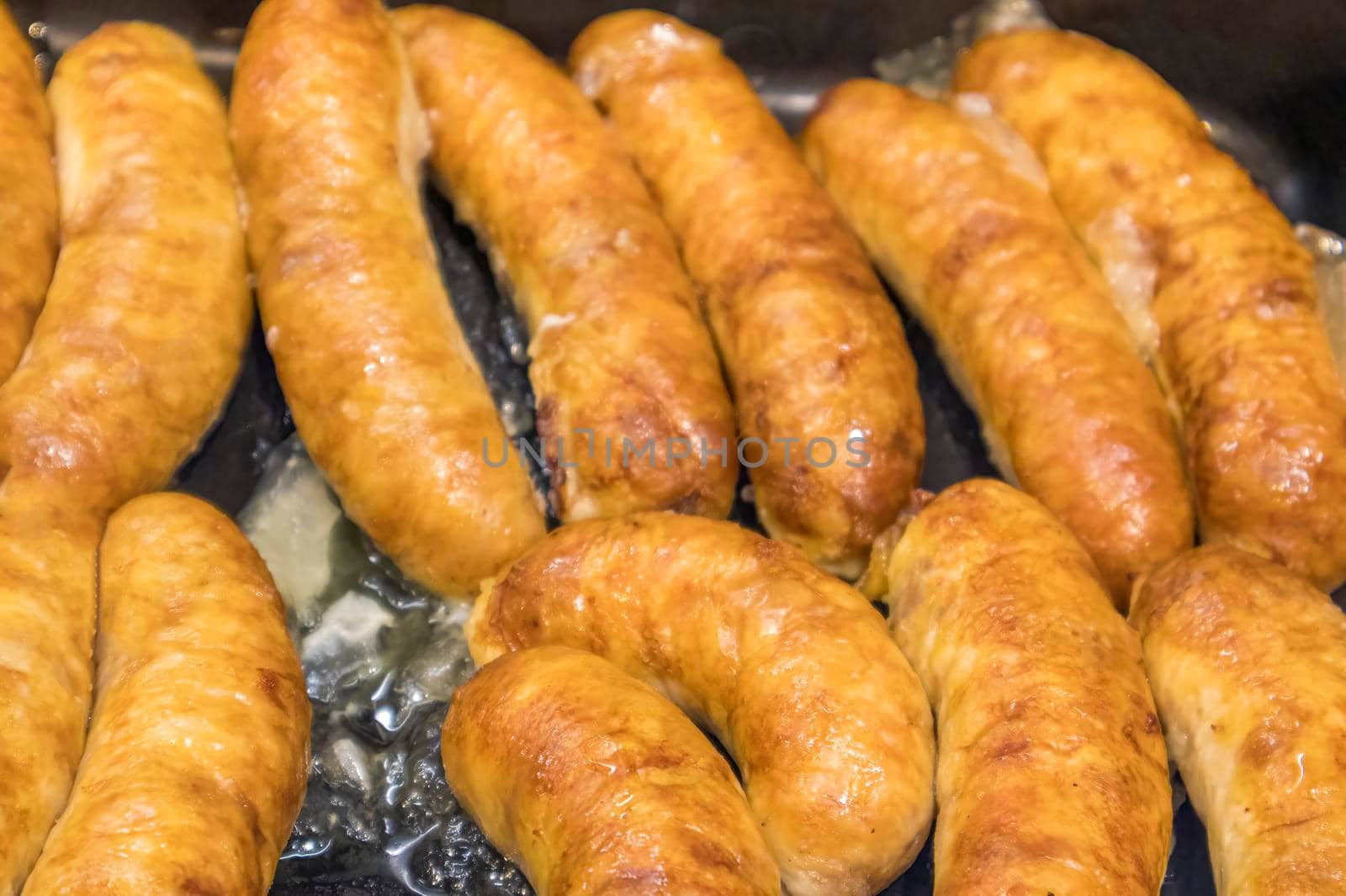 fried homemade rustic sausages close-up as background by roman112007