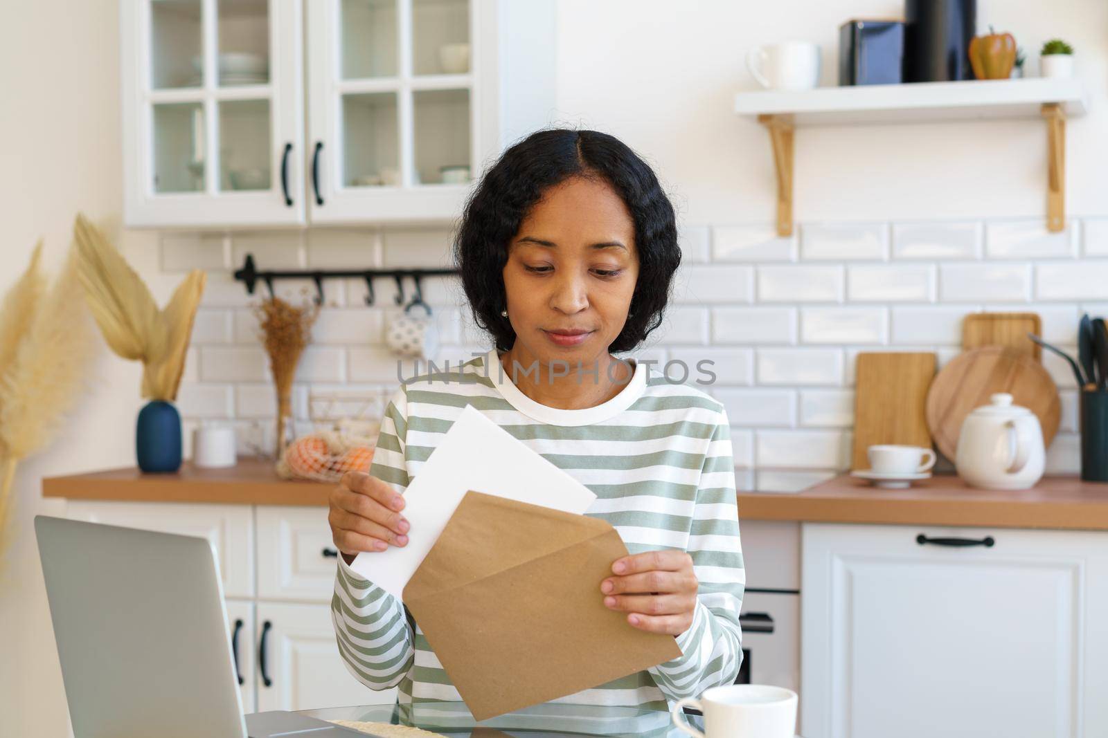 African-american female sending letter. Preparing correspondence for mail delivery. Closing envelope by NataBene