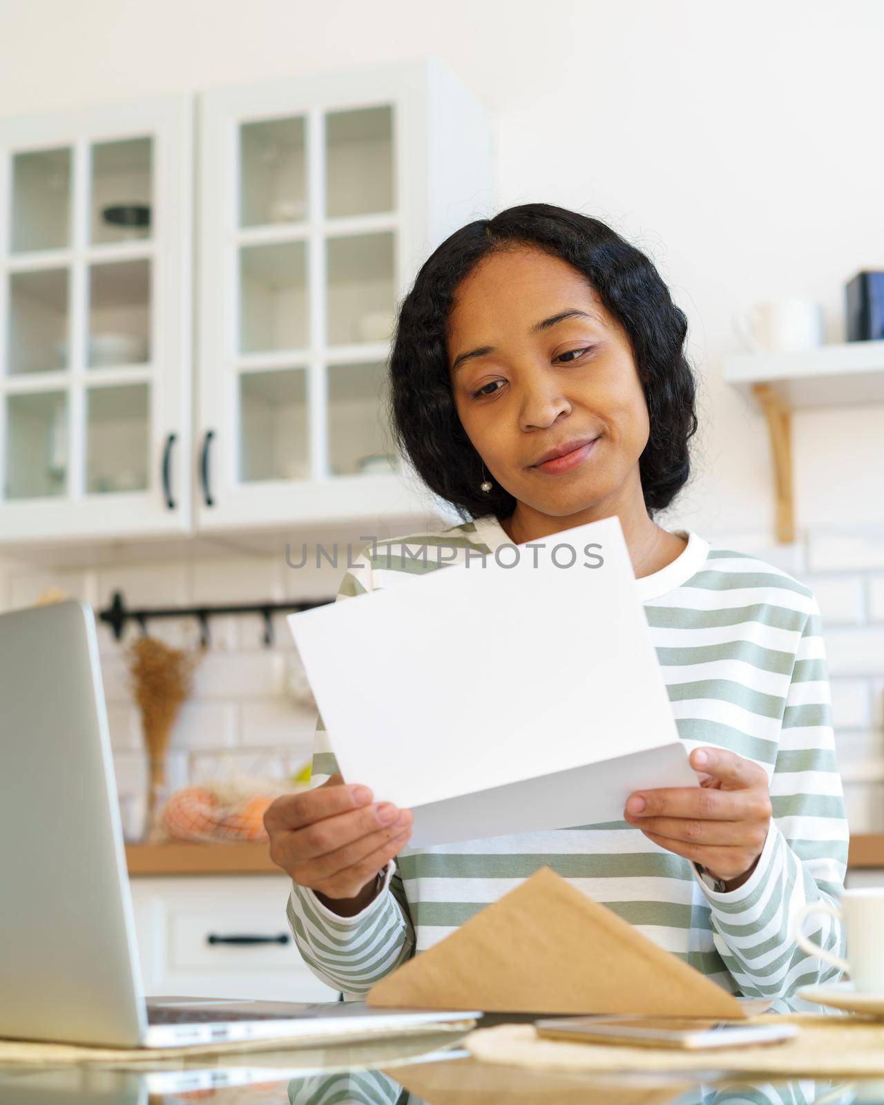 Young african-american female opening and reading letter. Concept of receiving mail correspondence by NataBene