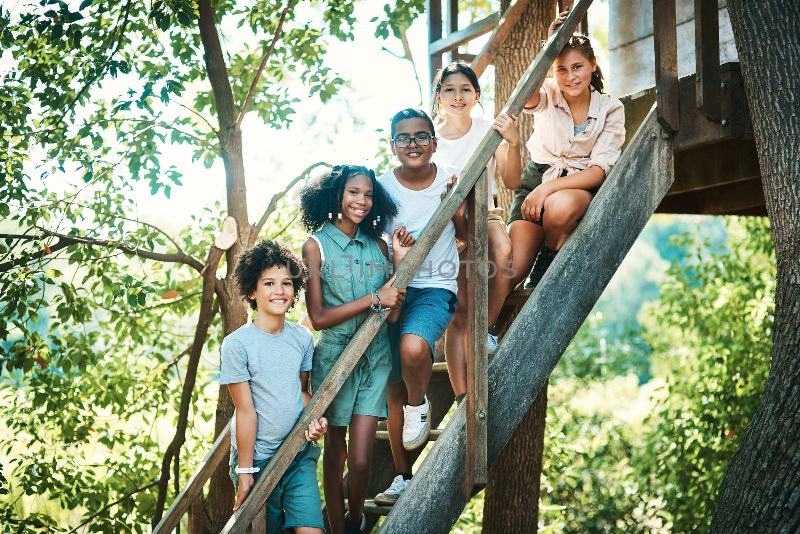Shot of a group of teenagers standing next to a treehouse at summer camp.