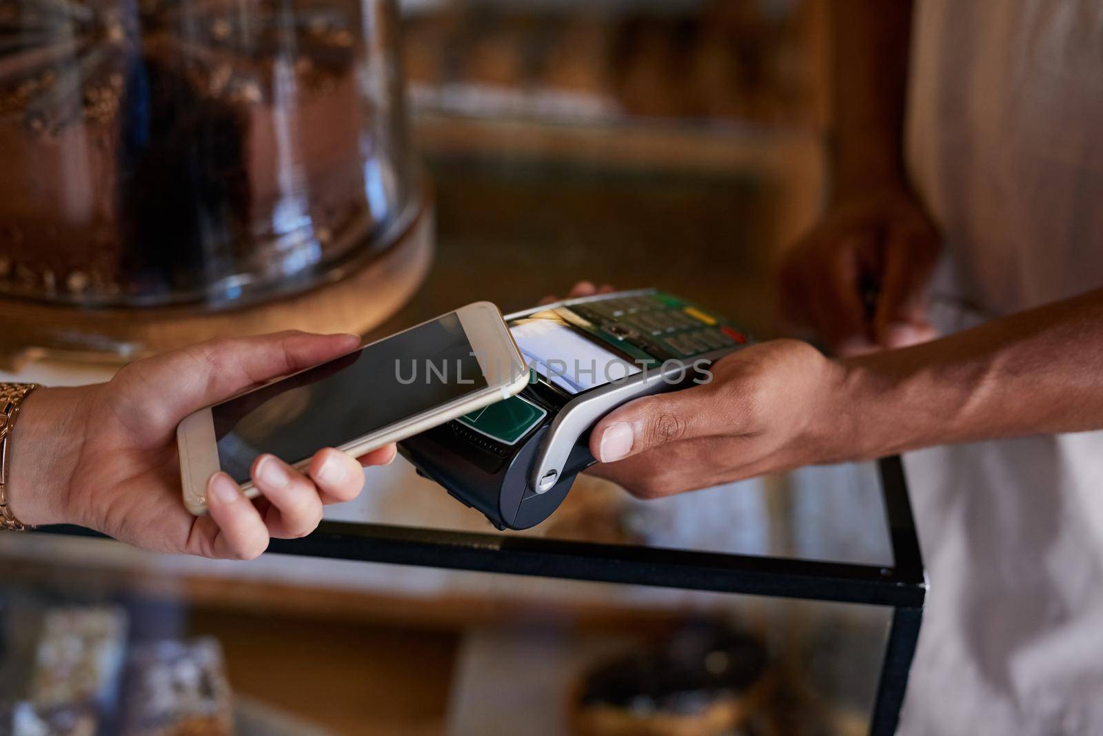 Closeup shot of a customer paying using NFC technology in cafe.