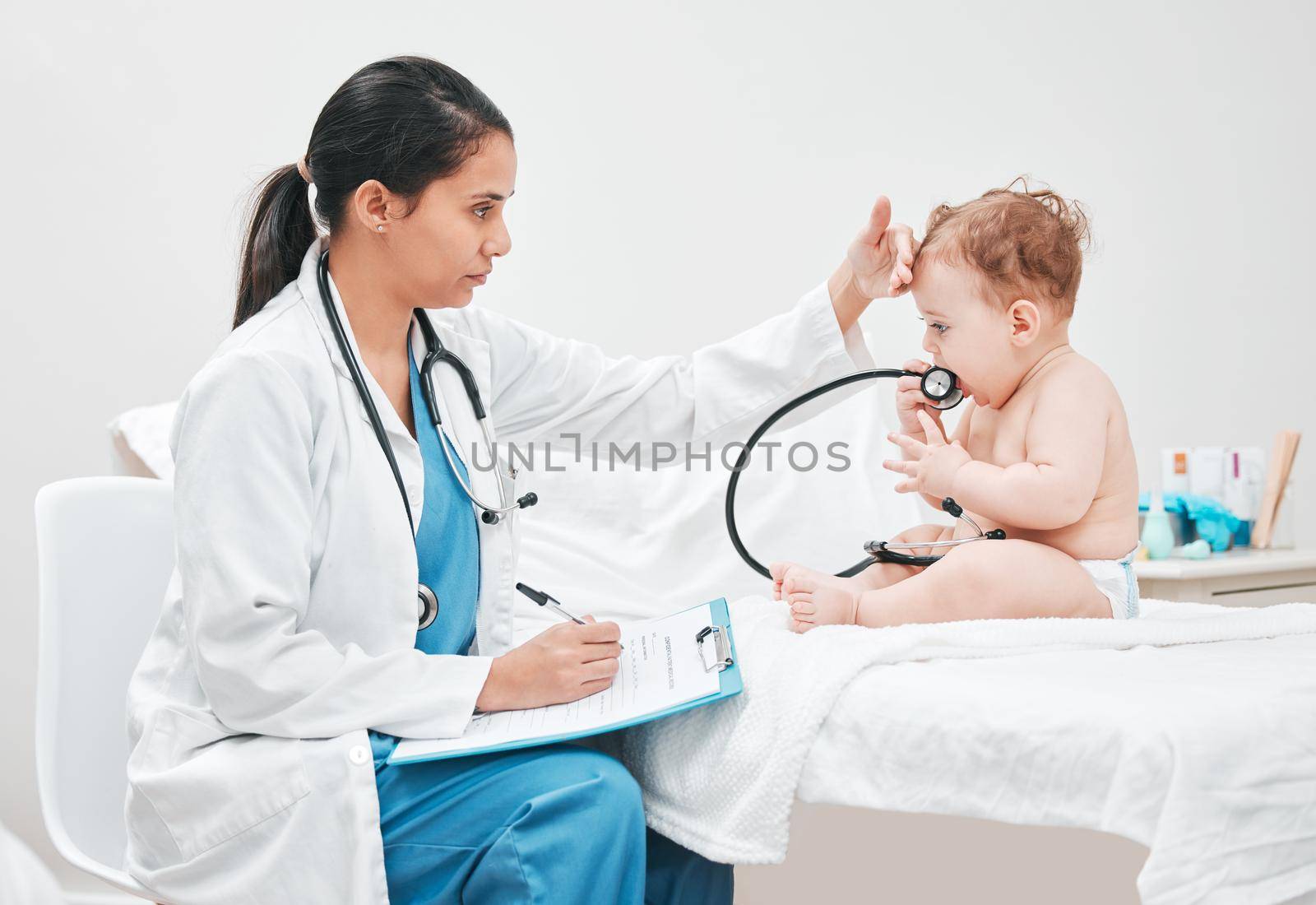 Shot of a paediatrician completing paperwork during a checkup.