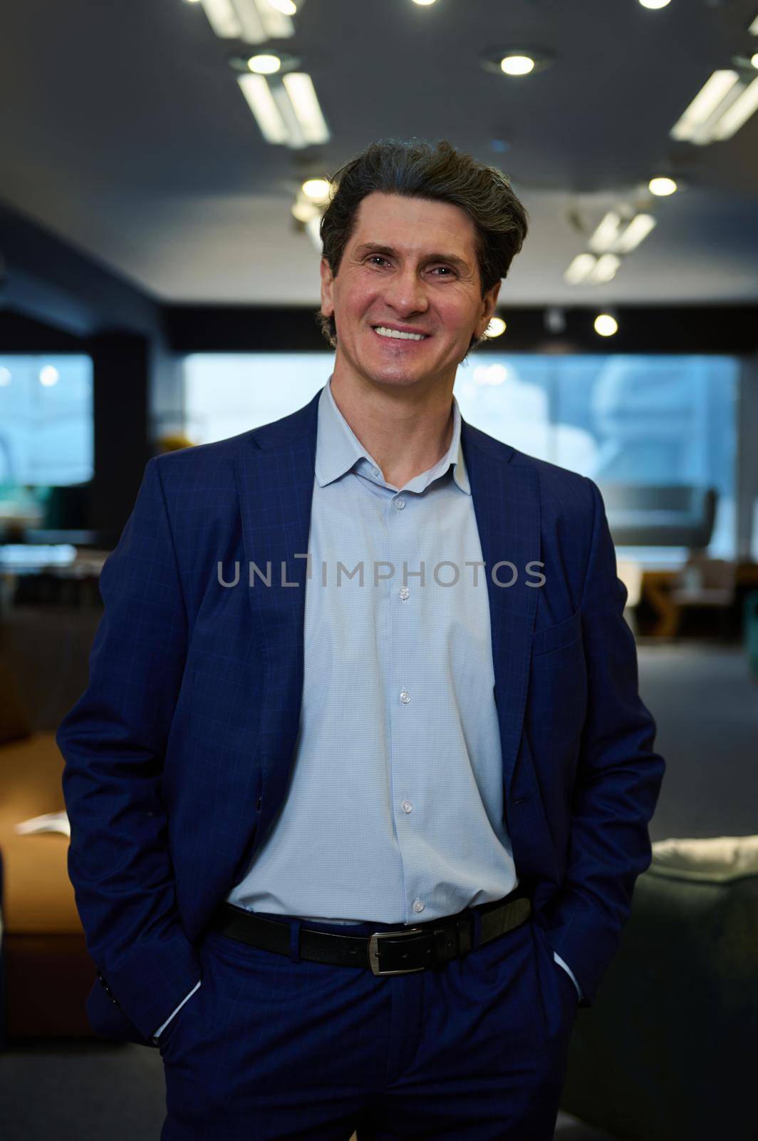 Business portrait of a handsome confident mature Caucasian man, entrepreneur, business owner, smiling with a beautiful toothy smile looking at camera