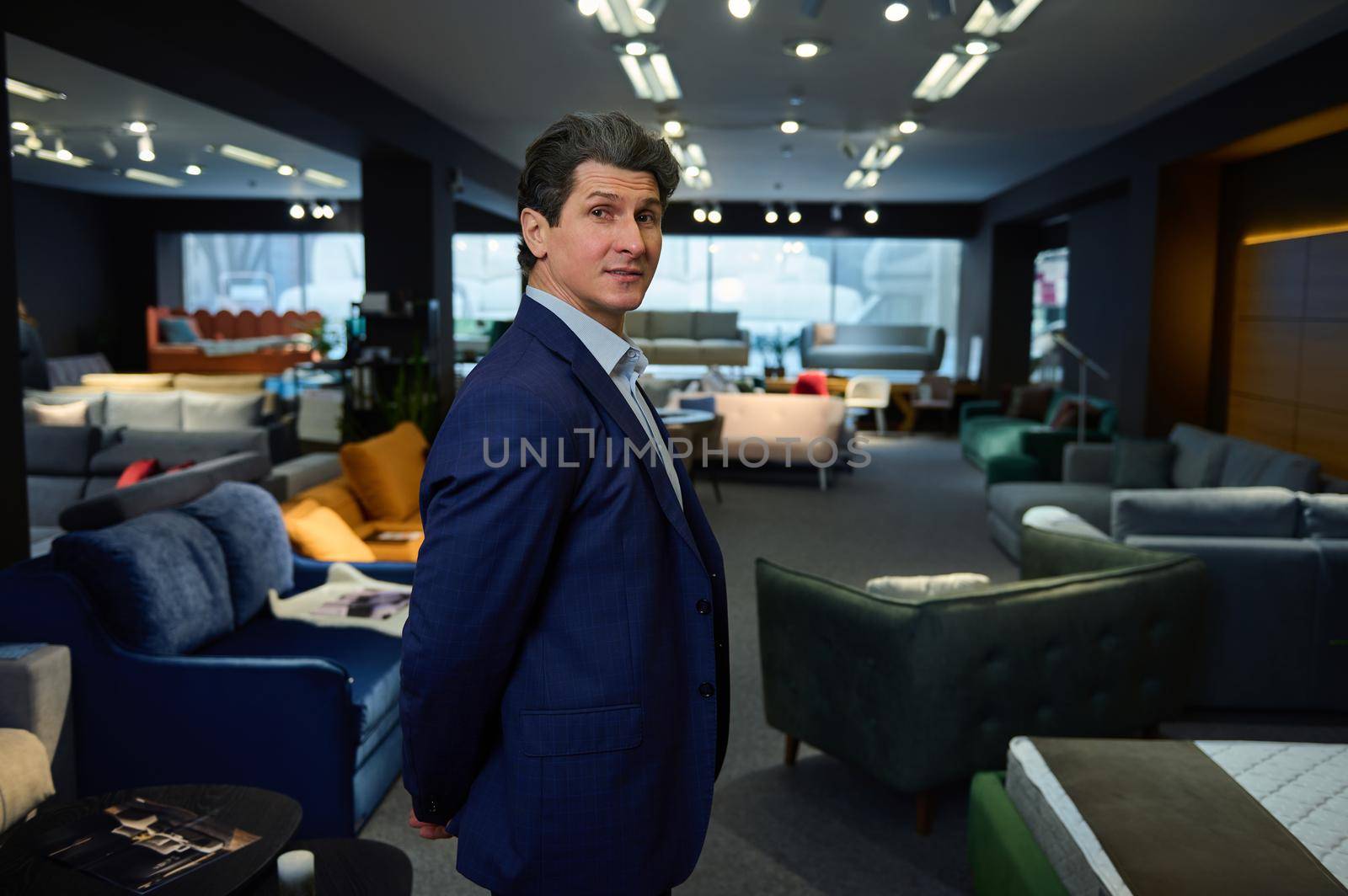 Confident business owner, entrepreneur, handsome mature man in a furniture store showroom by artgf