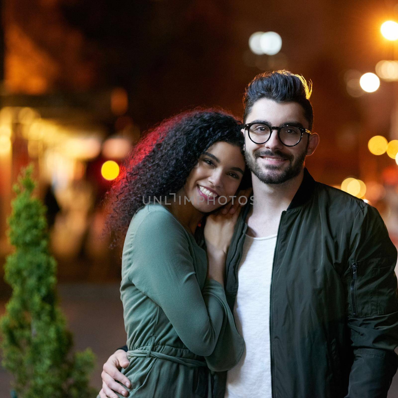 Portrait of a happy young couple outdoors at night.