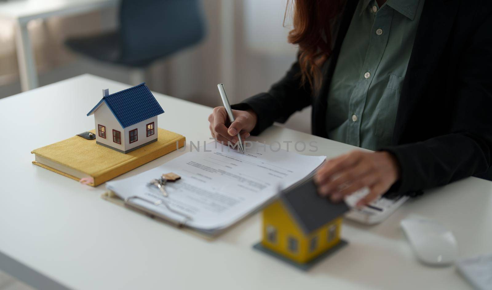 Close up hand of real estate investment and home insurance signing contracts in accordance with the home buying insurance agreements approving purchases for clients by nateemee