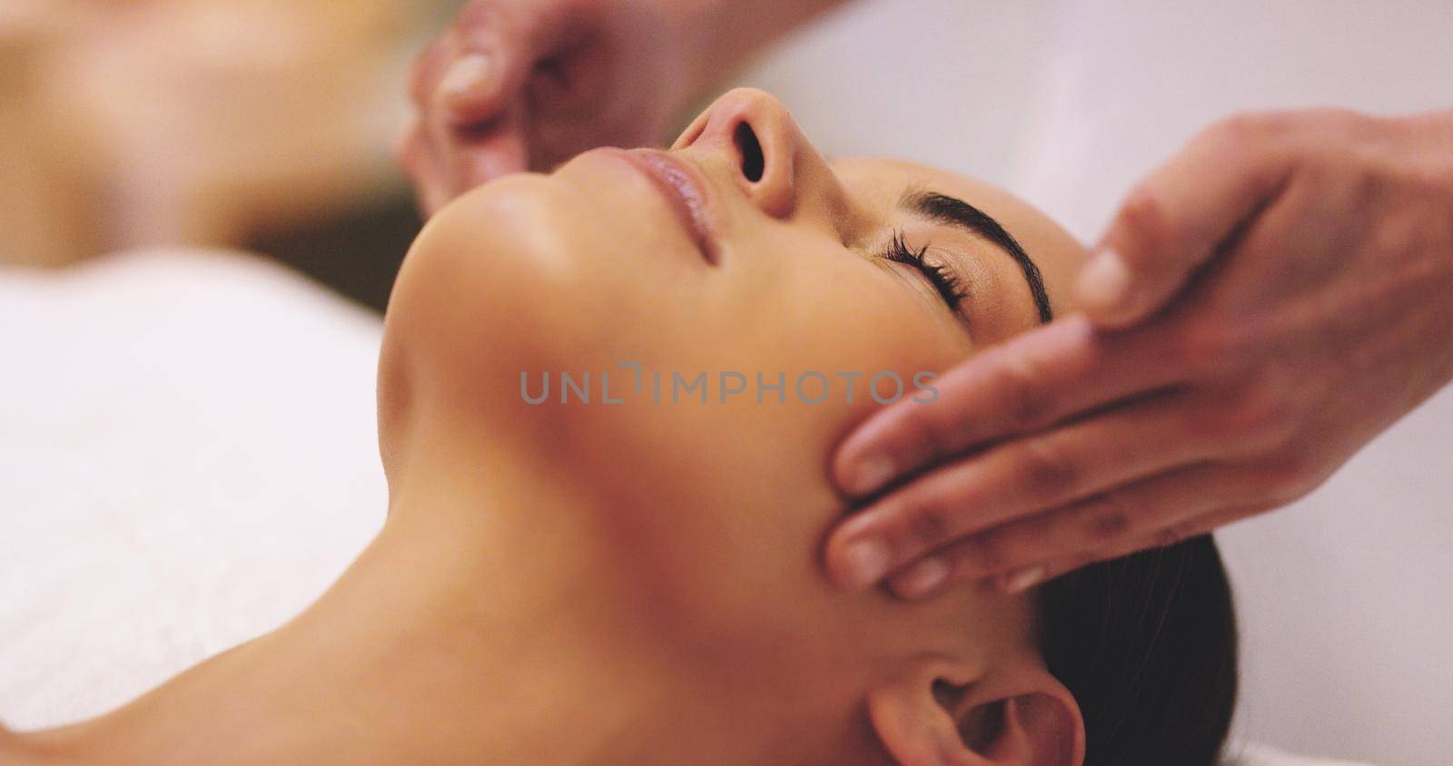Shot of a beautiful young woman enjoying a head massage at a beauty spa.