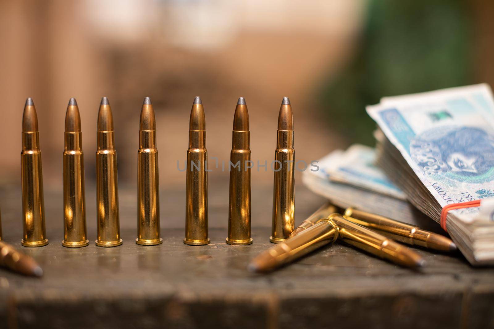 A few rifle cartridges stand on a crate next to a thick file of banknotes. Money for ammunition for those fighting at the front.