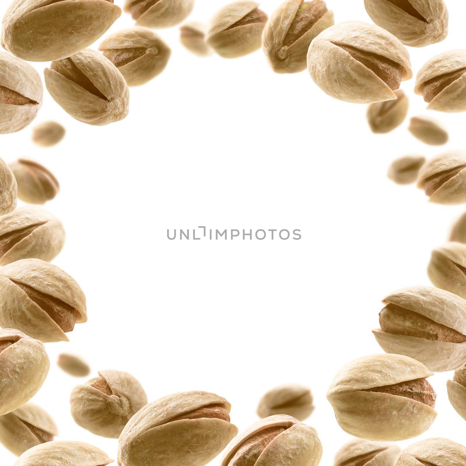 Salted pistachios levitate on a white background by butenkow