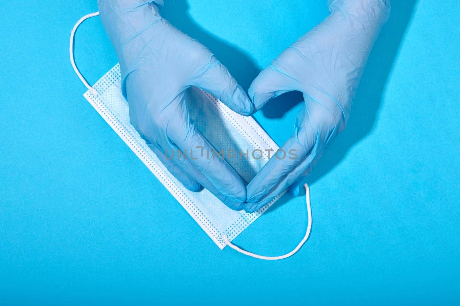 Hands in latex gloves medical mask blue background by Demkat