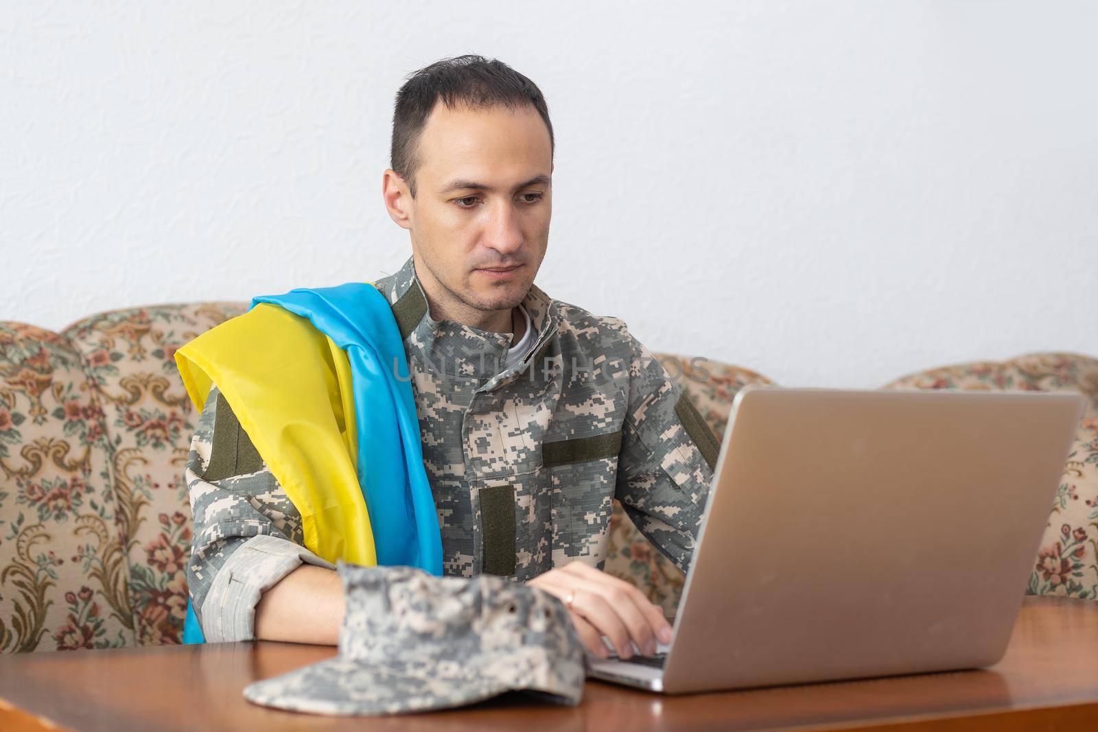 Stand with Ukraine on Social Media concept background with Laptop. military with the flag of Ukraine.