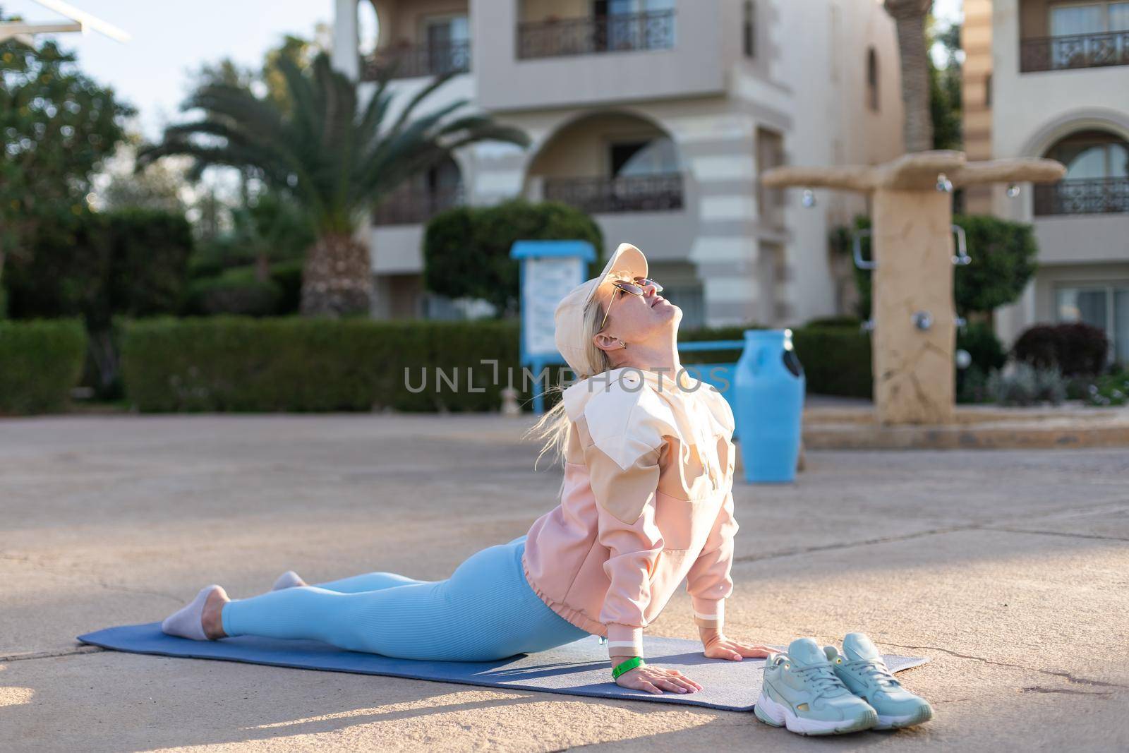 Good morning with yoga meditating on sunrise background. Active woman practicing at villa poolside to keep fit and health. Woman fitness training, sport activity on summer family holiday. by Andelov13