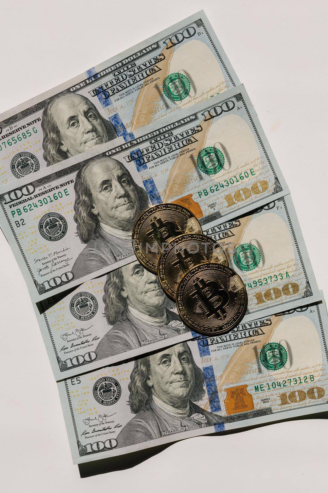 Bitcoin on banknotes of one hundred dollars. Exchange US dollars for bitcoin. Cryptocurrency on dollar bills. Digital modern method of payment. Concep of virtual money.
