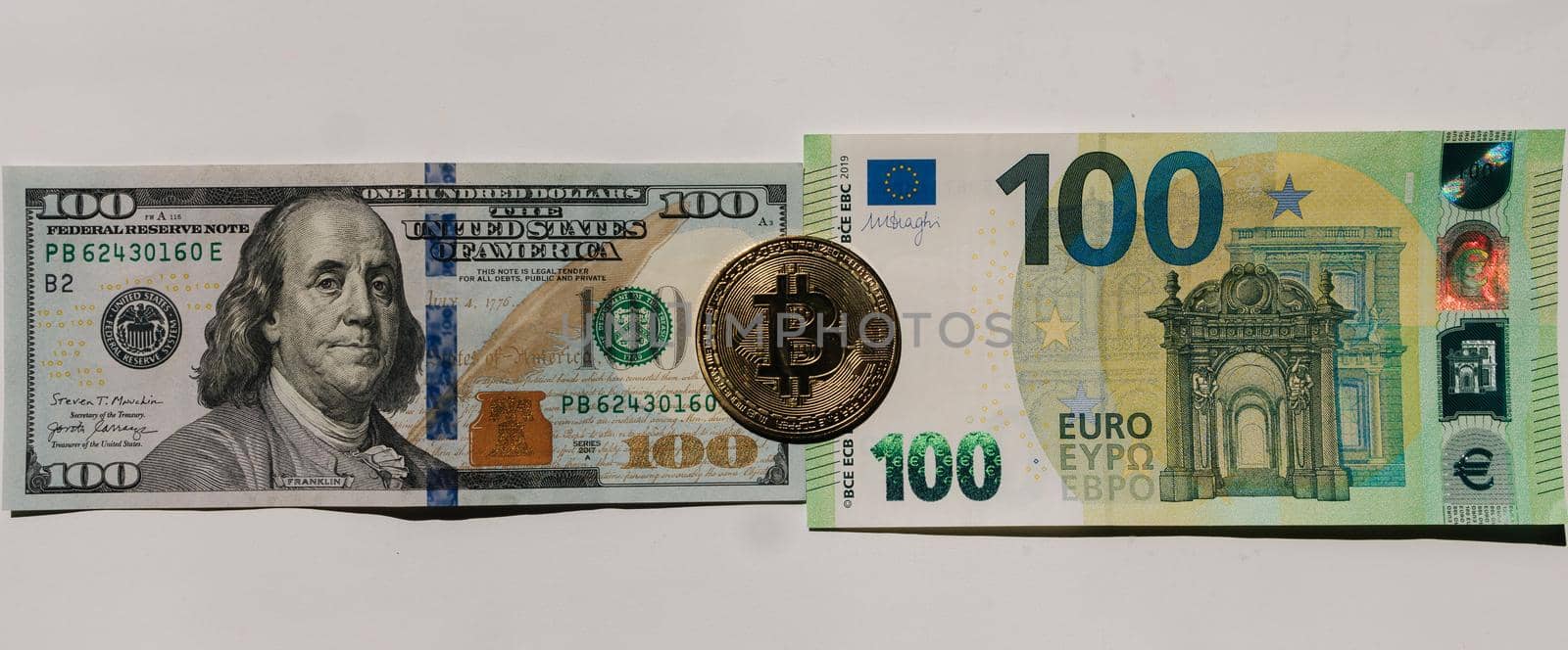 Digital cryptocurrency gold bitcoin lying between US Dollar and Euro banknotes. Difference between virtual money and cash. Concept of new virtual money. Top view.