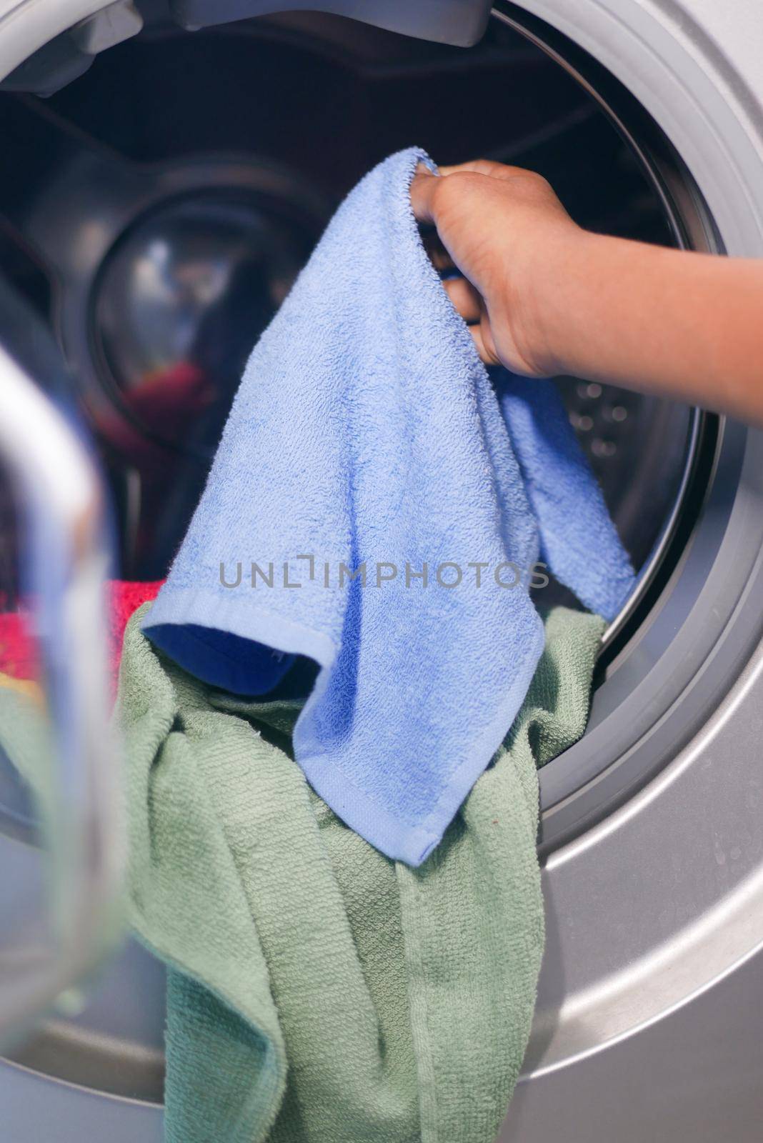 putting towel and cloths in a washing machine. by towfiq007