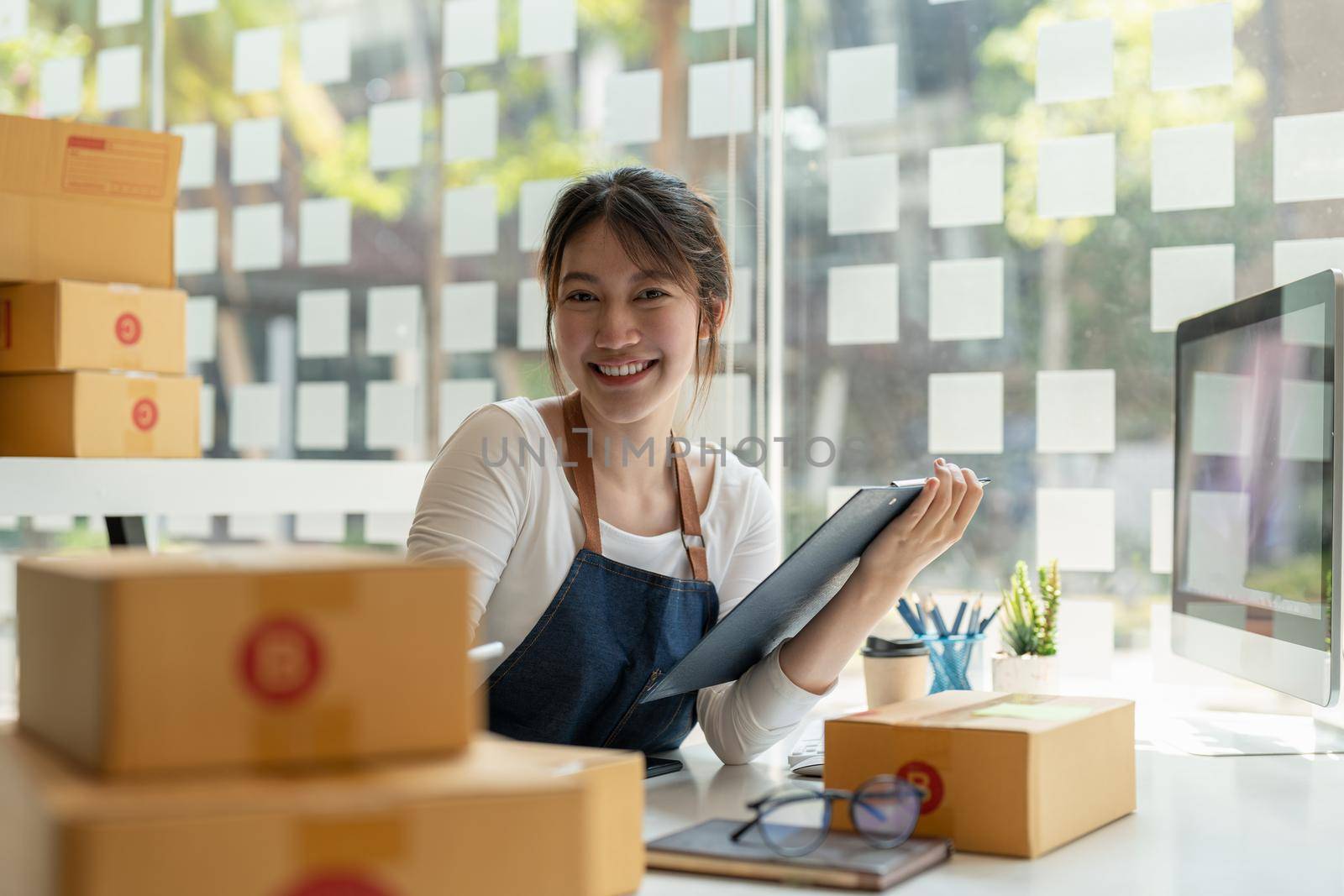 Portrait of Asian young woman SME working with a box at home the workplace.start-up small business owner, small business entrepreneur SME or freelance business online and delivery concept.