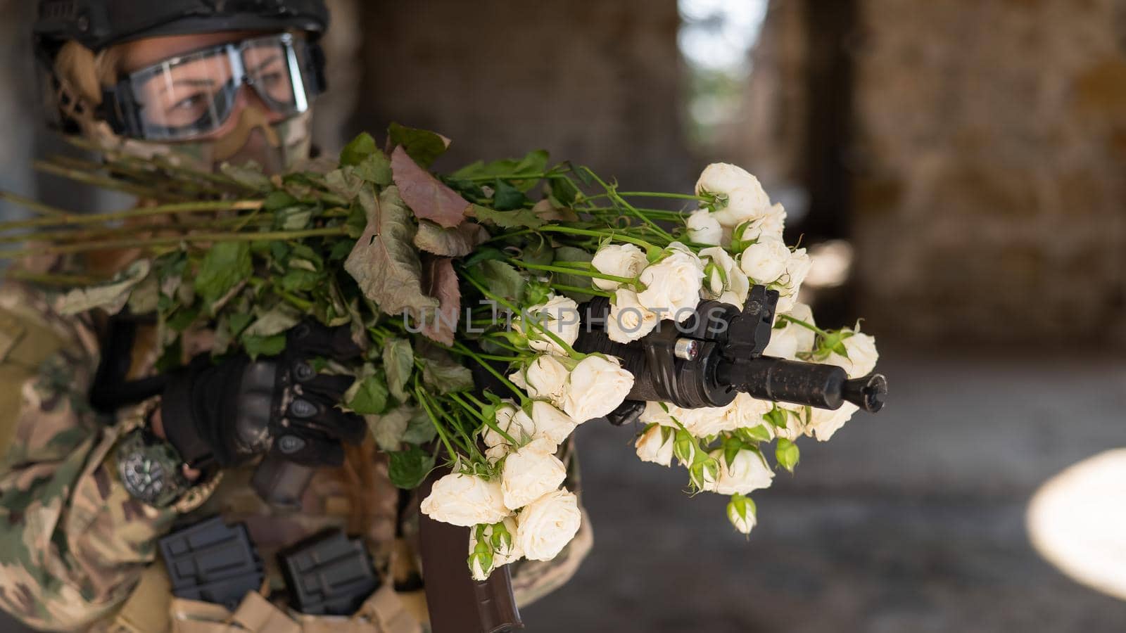 Caucasian woman in military uniform holding a machine gun and a bouquet of white roses. by mrwed54