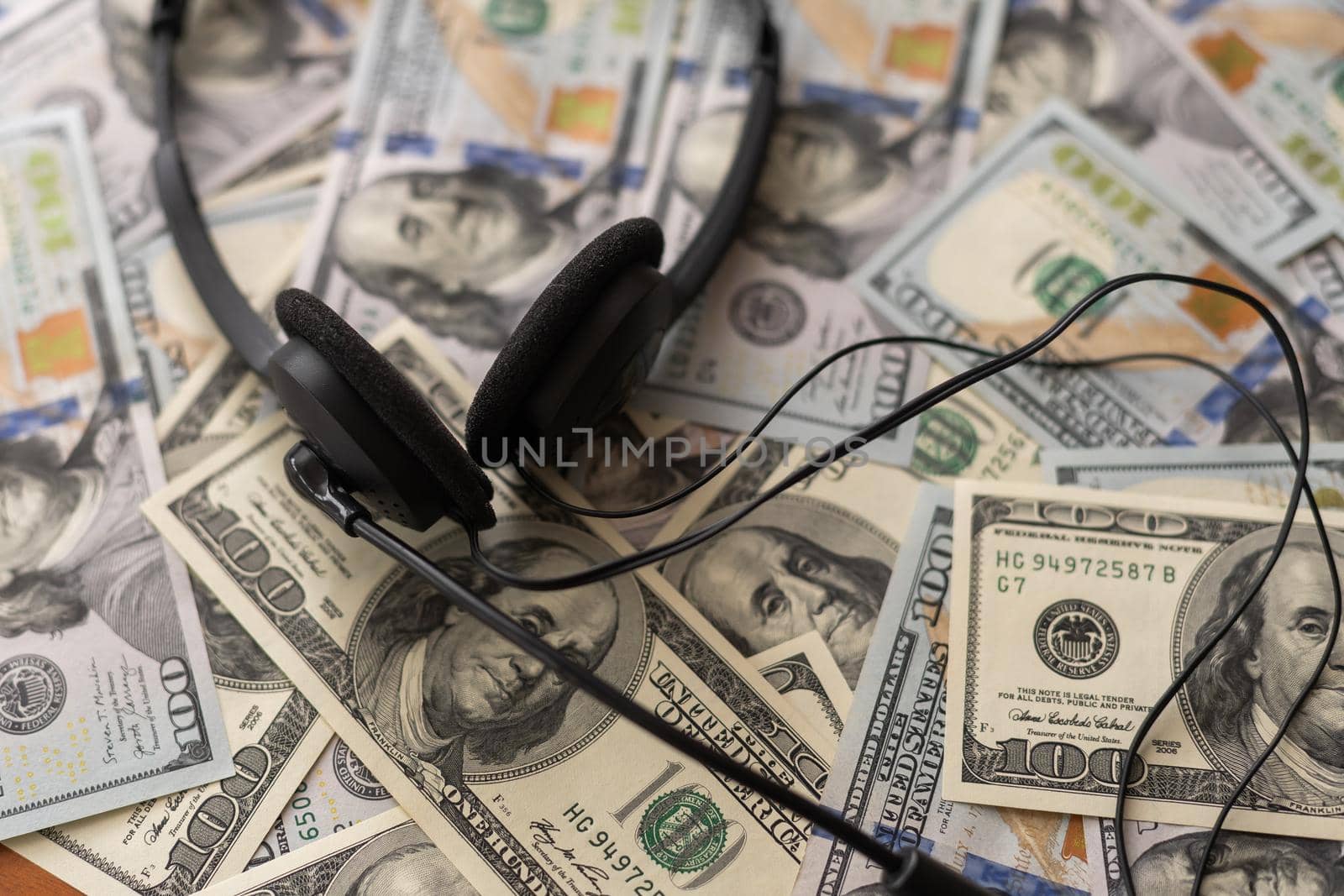 Headphones and American cash money on table.