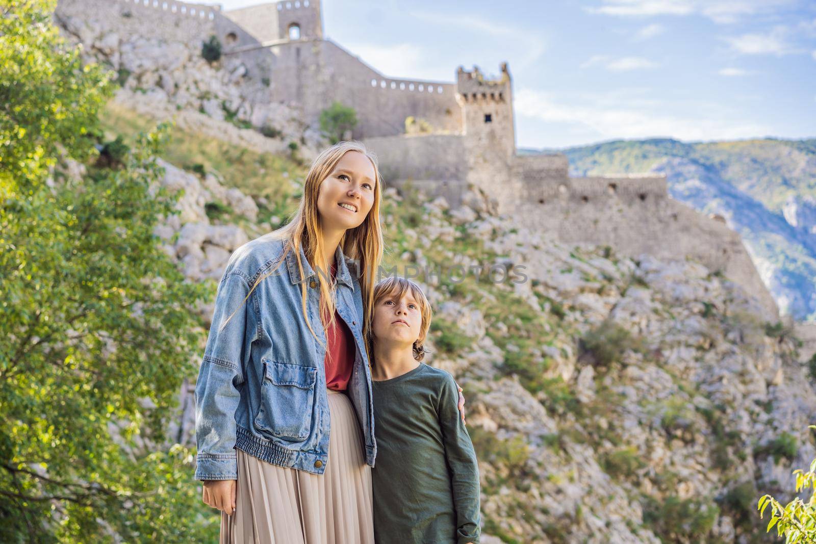 Mother and son travellers enjoys the view of Kotor. Montenegro. Bay of Kotor, Gulf of Kotor, Boka Kotorska and walled old city. Travel with kids to Montenegro concept. Fortifications of Kotor is on UNESCO World Heritage List since 1979 by galitskaya