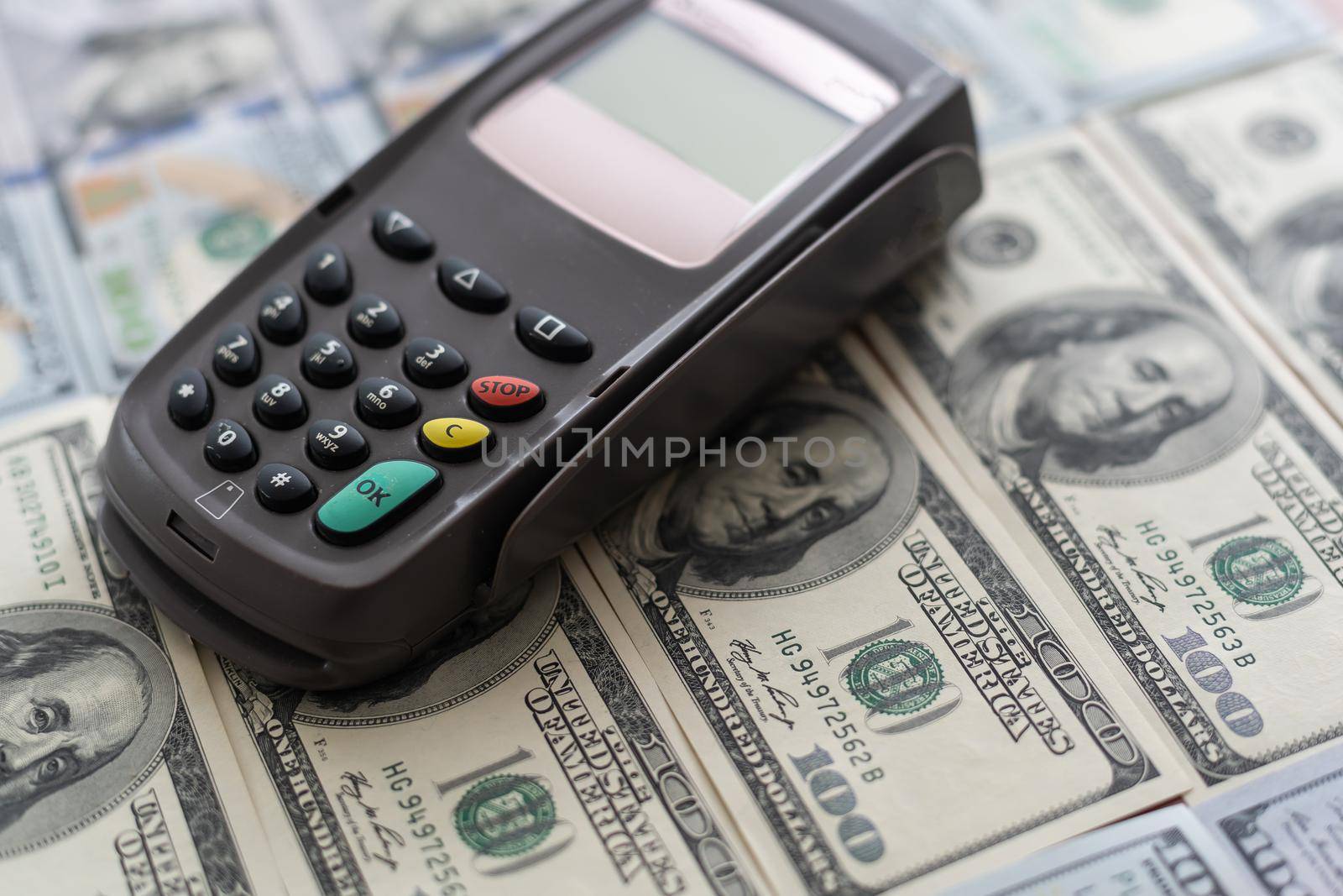 Terminal for cashless payments. Concept - refusal of cash transactions. Hundred dollar bills near cash register terminal. Concept - sale equipment for working with bank cards. Payment upon purchase by Andelov13