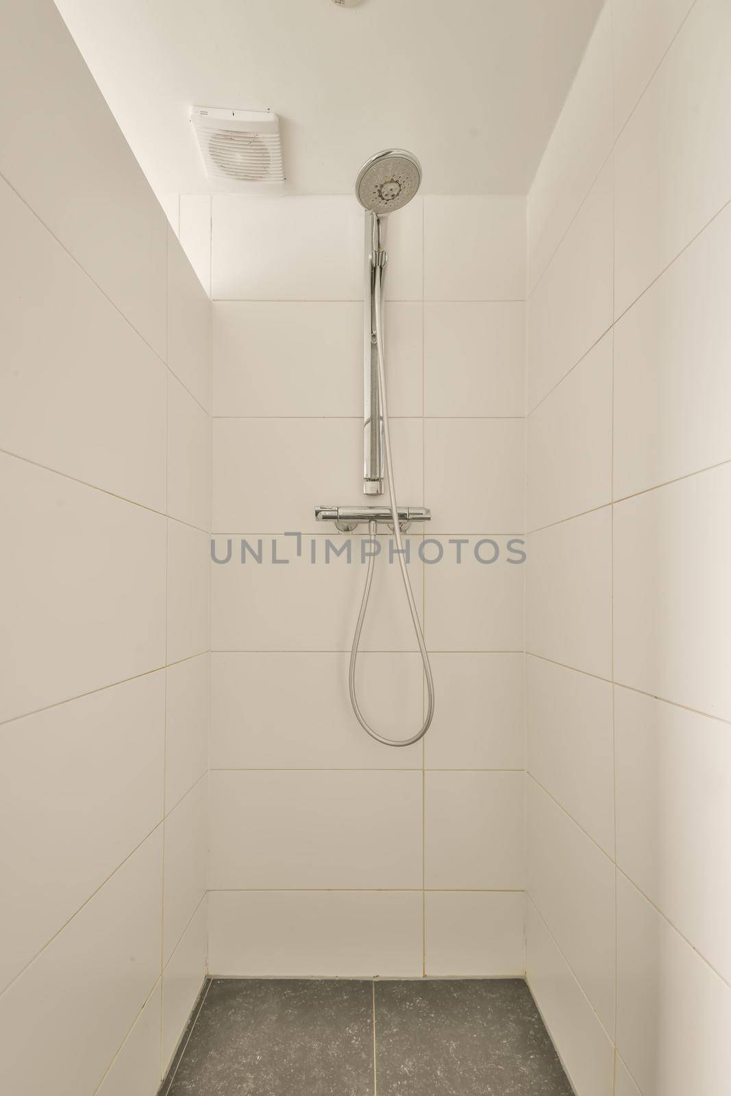 The interior of a shower cabin decorated with white and black tiles in a modern house