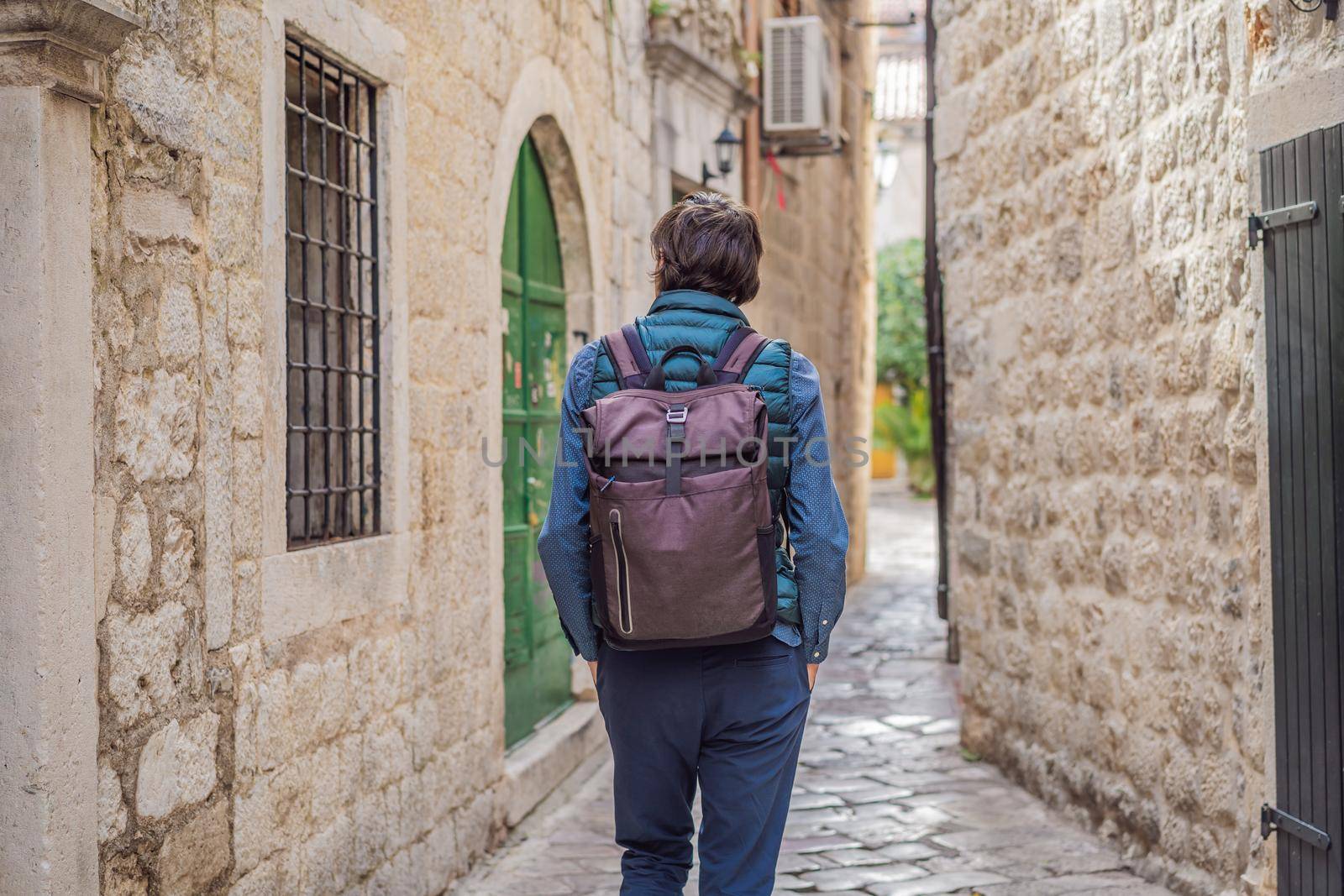 Man tourist enjoying Colorful street in Old town of Kotor on a sunny day, Montenegro. Travel to Montenegro concept.