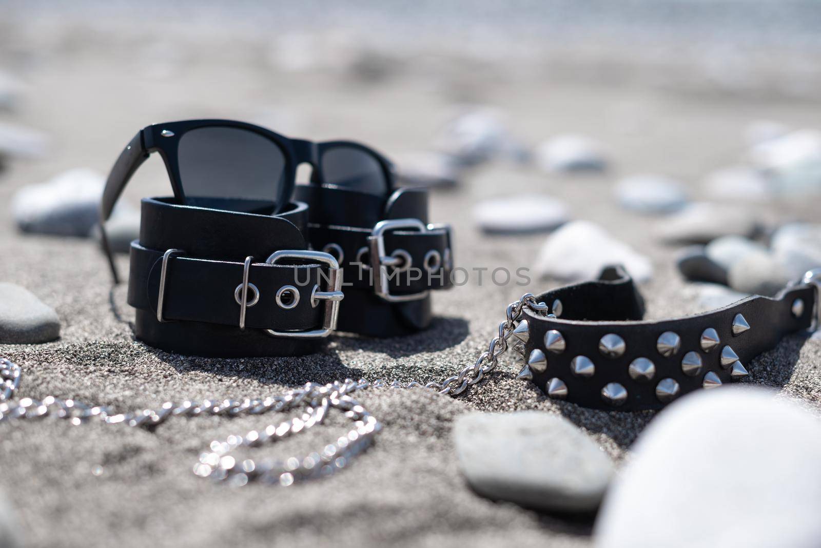 leather handcuffs for bdsm sex toys on a sandy beach