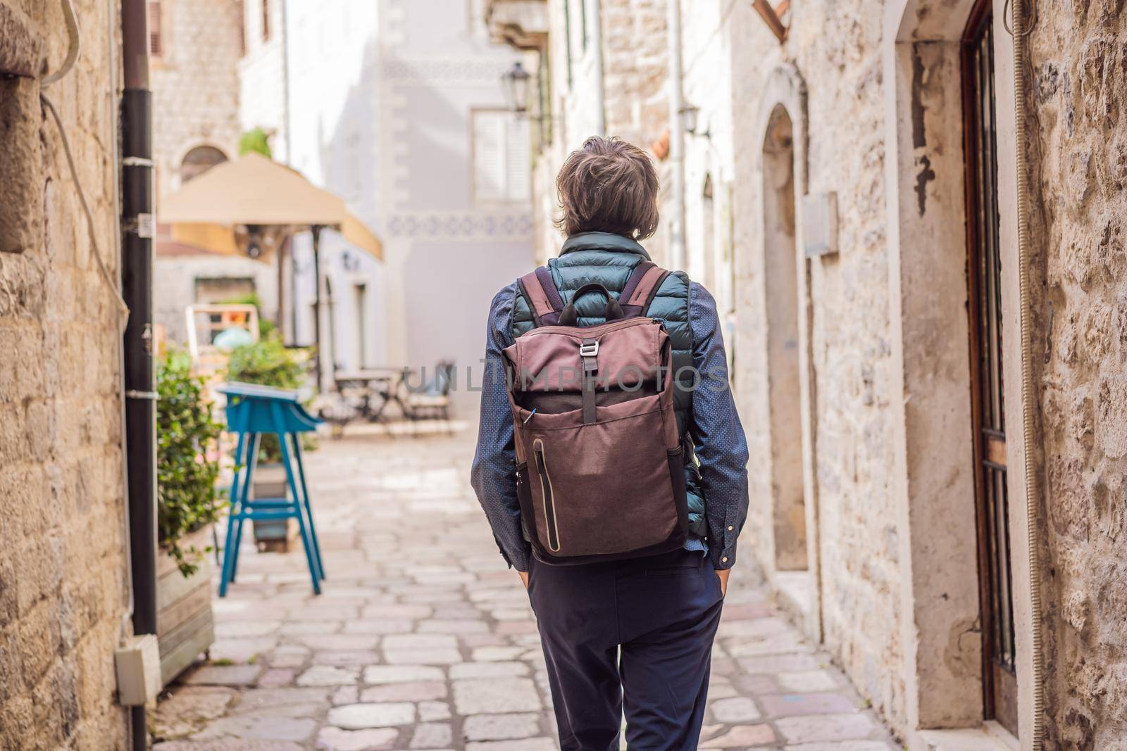 Man tourist enjoying Colorful street in Old town of Kotor on a sunny day, Montenegro. Travel to Montenegro concept.