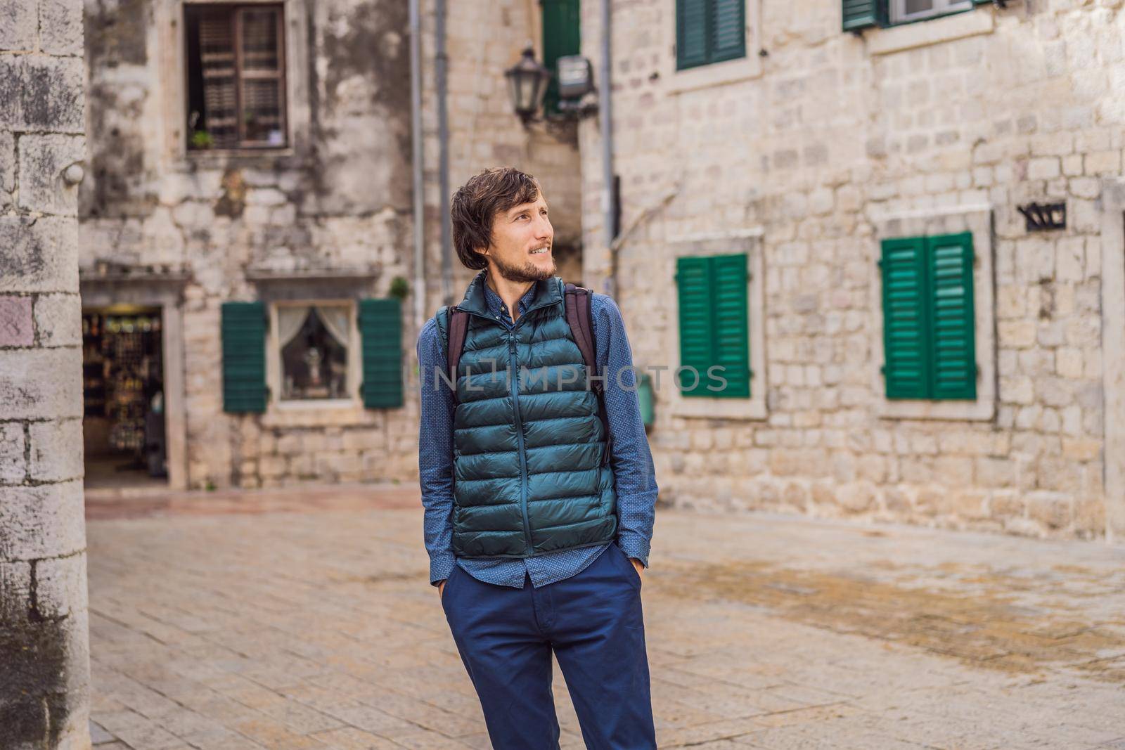 Man tourist enjoying Colorful street in Old town of Kotor on a sunny day, Montenegro. Travel to Montenegro concept.