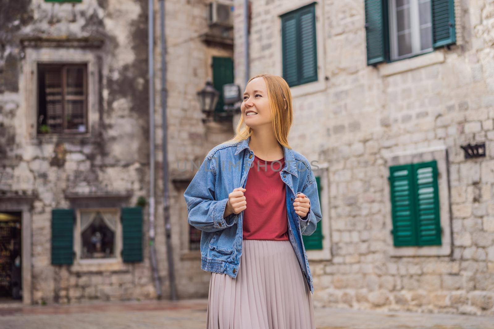 Woman tourist enjoying Colorful street in Old town of Kotor on a sunny day, Montenegro. Travel to Montenegro concept.