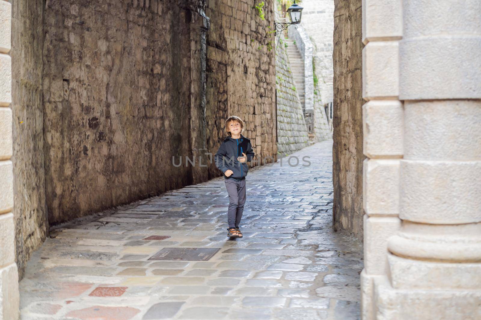 Boy tourist enjoying Colorful street in Old town of Kotor on a sunny day, Montenegro. Travel to Montenegro concept.