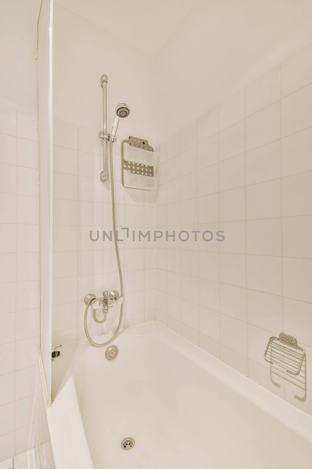 White bathtub with shower and ceramic tiles