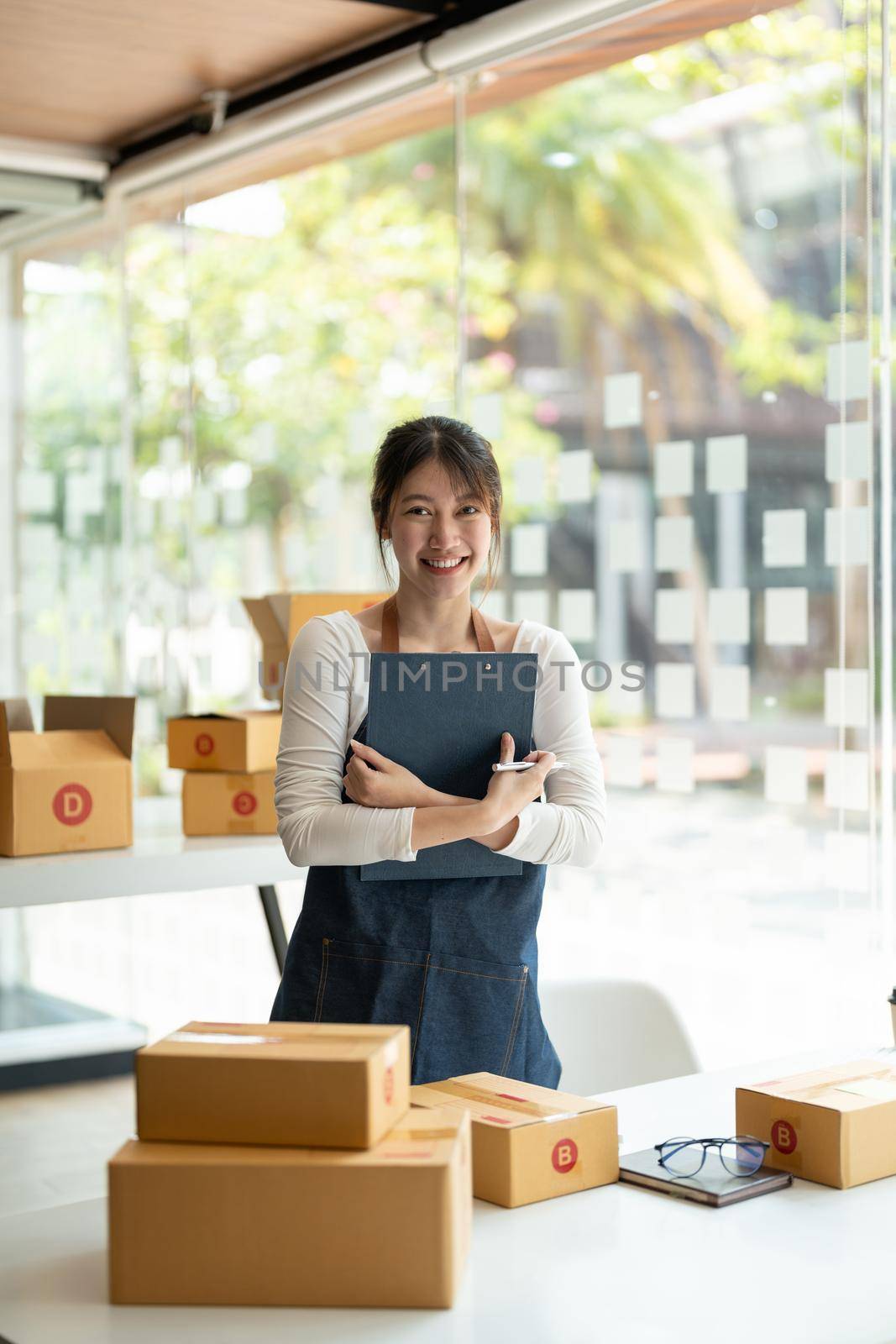 Portrait of Asian young woman SME working with a box at home the workplace.start-up small business owner, small business entrepreneur SME or freelance business online and delivery concept by nateemee