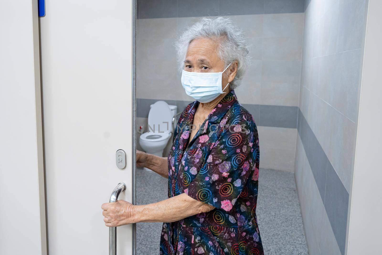 Asian senior elderly old lady woman patient open toilet bathroom by hand in nursing hospital ward, healthy strong medical concept. by pamai
