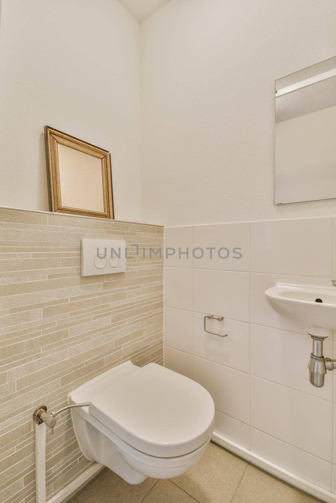 Bathroom interior finished with white tiles with a toilet and sink in a modern house