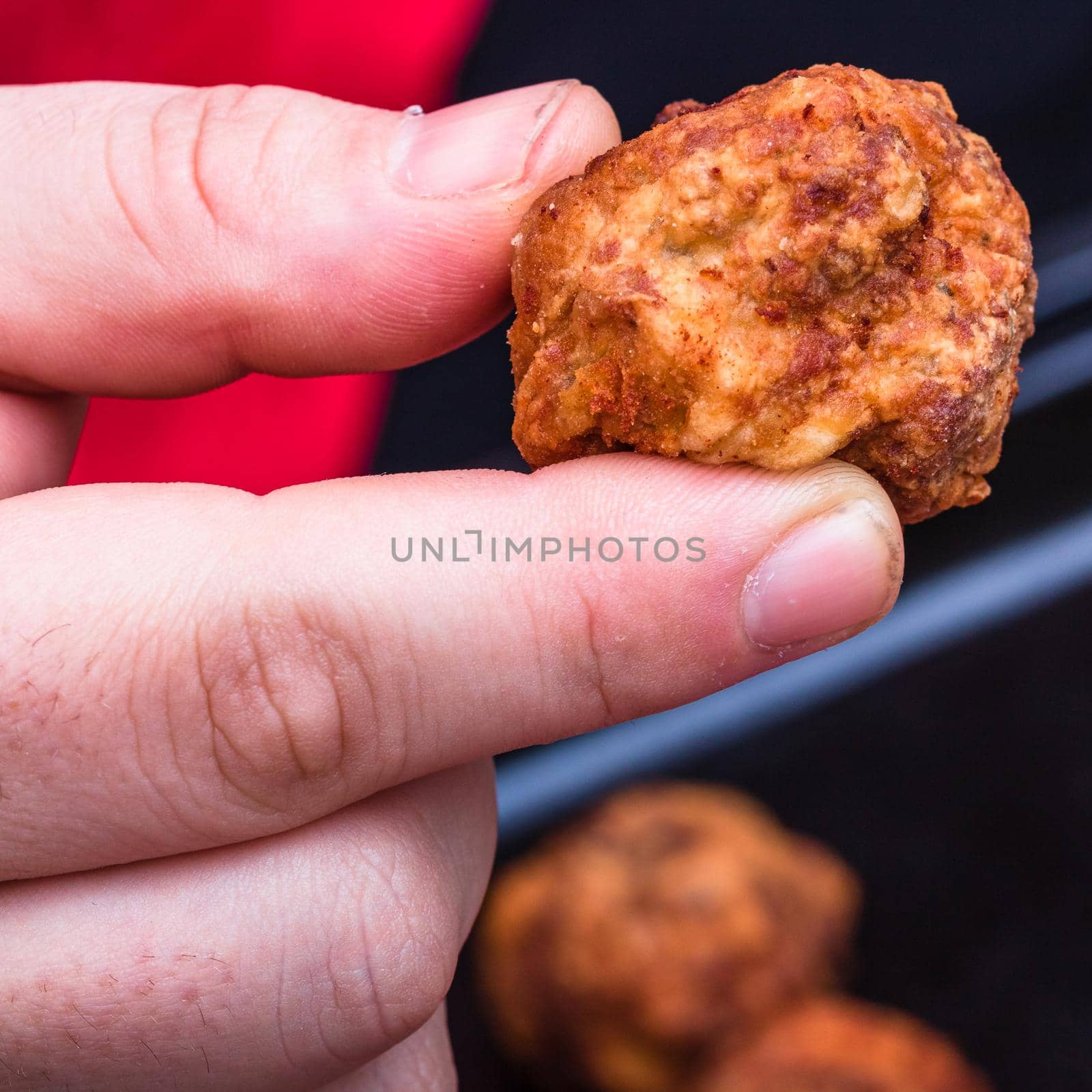 Details of fresh fried meatballs with spices. homemade food. Hand holding a fried meatball.