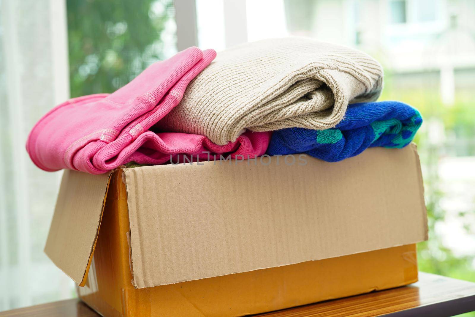 Clothes donations in cardboard box for volunteer.