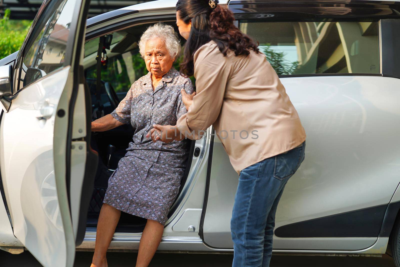 Caregiver help Asian elderly woman disability patient get in her car, medical concept. by sweettomato