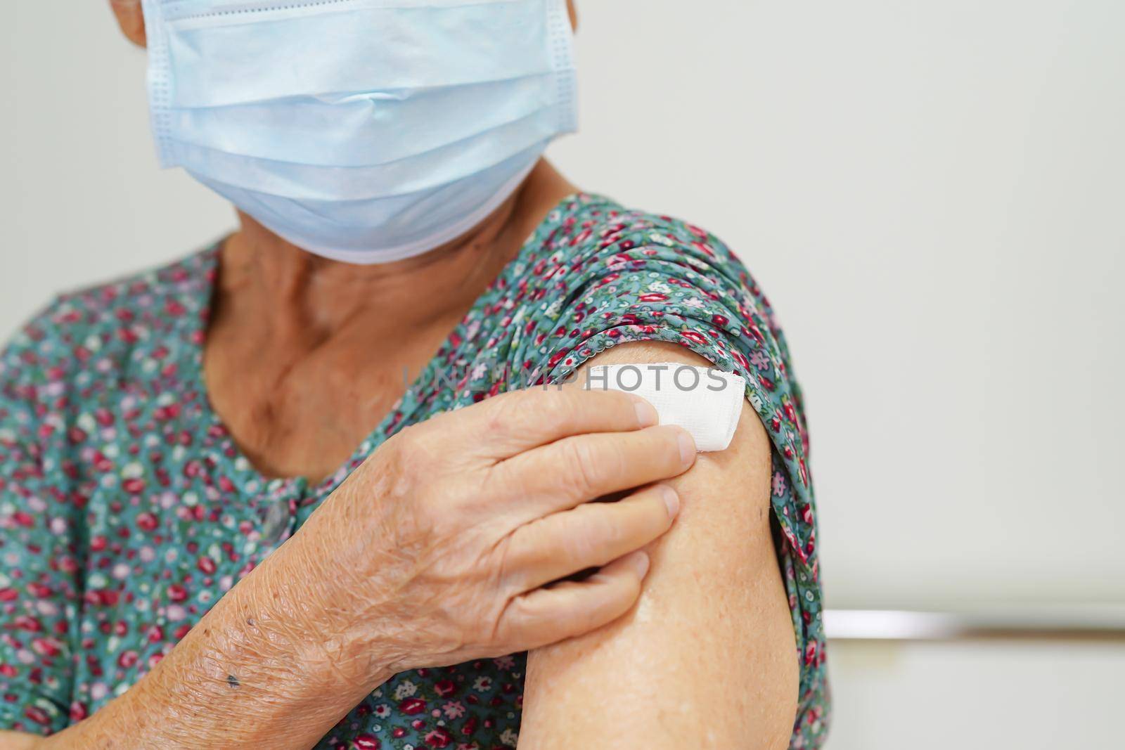 Asian elder senior woman with protective face mask getting vaccine for protect corona virus.