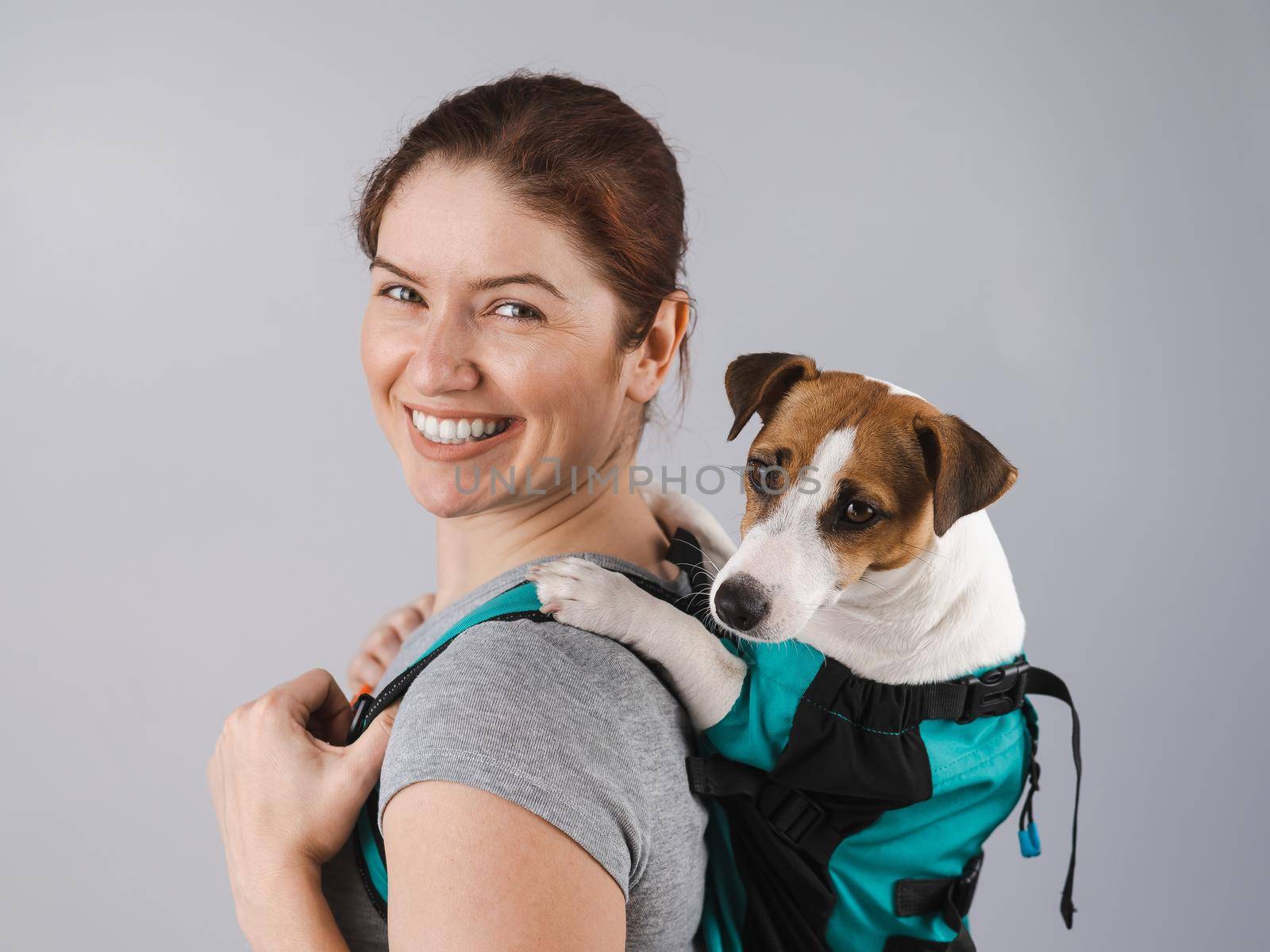 Caucasian woman carries jack russell terrier dog in her backpack