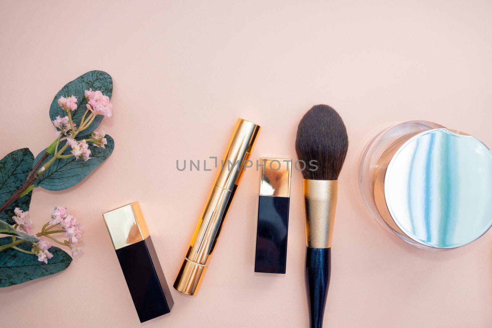 set of beauty cosmetics for female face and eye makeup on pink background . photo