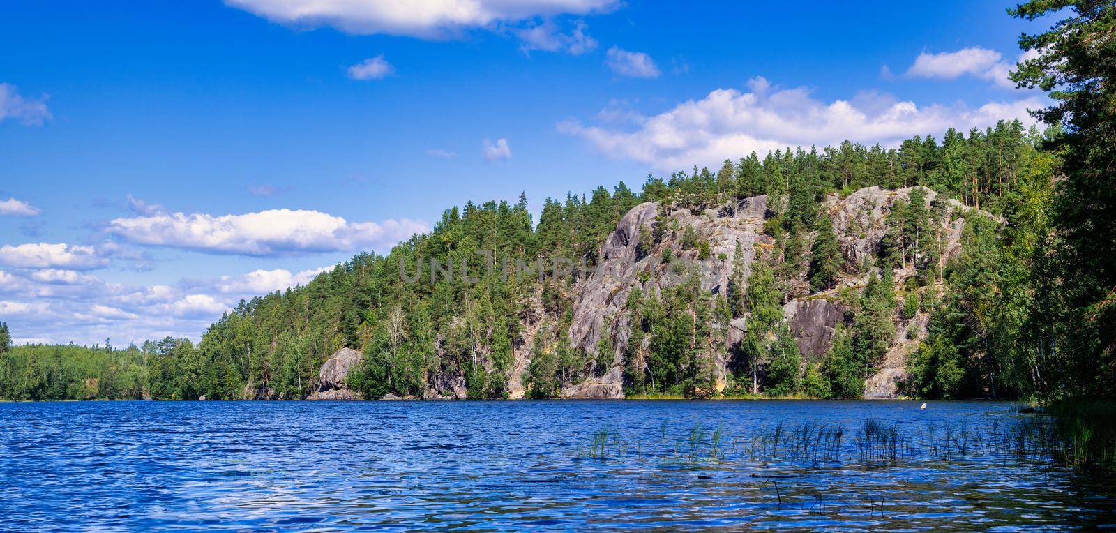 Landscape of the forest lake Yastrebinoye with ice age rocks in the background. Russia